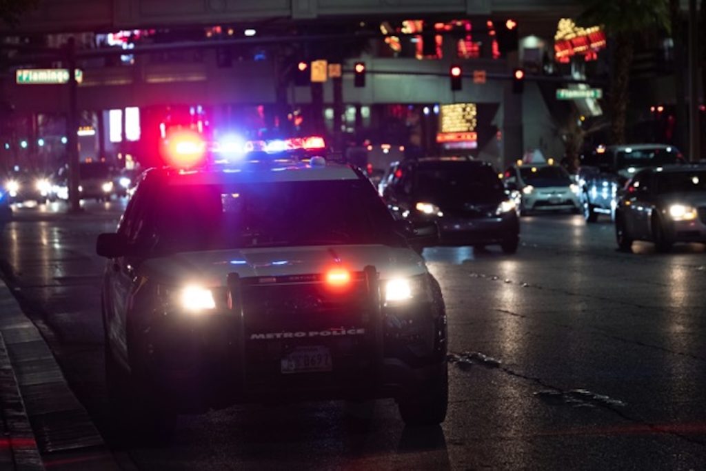 Police cruiser with flashing lights during a nighttime traffic stop in Colorado — illustrating aggravated driving with a revoked license cases.