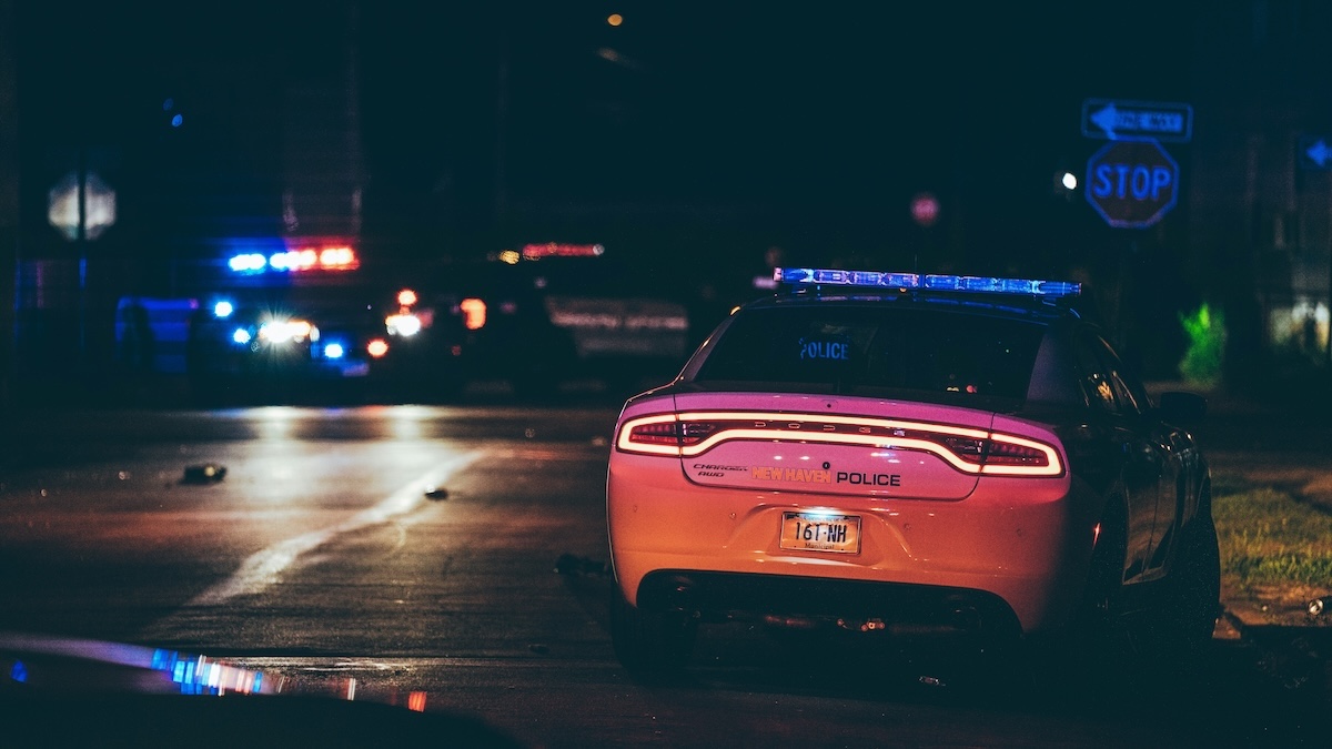 Police vehicles with flashing lights at night during a traffic stop, symbolizing felony traffic offenses in Colorado.