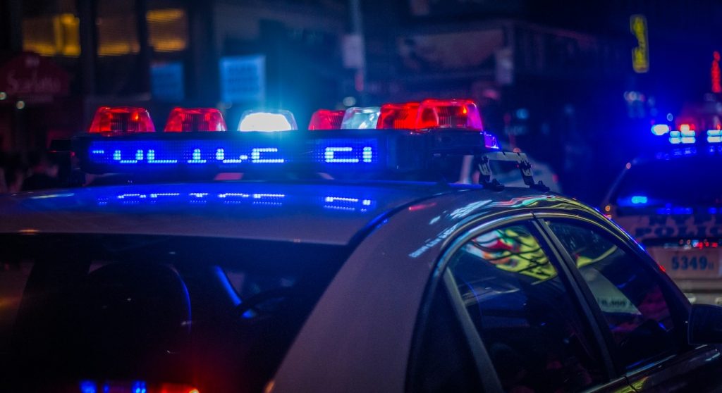 Police car with emergency lights activated at night during DUI patrol in Boulder, Colorado.